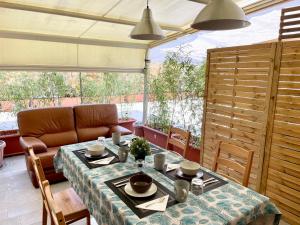 a dining room with a table and a couch at Bilocale con terrazza privata - Metro M1 to City Center in Sesto San Giovanni