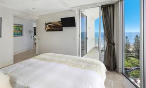 a bedroom with a bed and a large window at Oceans Mooloolaba in Mooloolaba