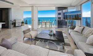 a living room with a couch and a table at Oceans Mooloolaba in Mooloolaba