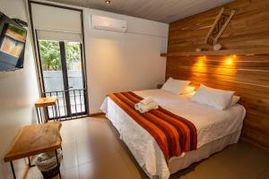 1 dormitorio con 1 cama con pared de madera en Hotel Cumbres del Sur, en Pucón