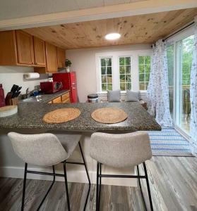 a kitchen with a counter with two chairs and a table at Cheerful 1 Bedroom Cottage Close to Everything 2 in Edgecomb