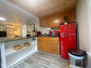a kitchen with a red refrigerator and wooden cabinets at Cheerful 1 Bedroom Cottage Close to Everything 2 in Edgecomb