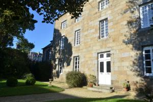 un antiguo edificio de piedra con una puerta blanca en Maison de Benedicte en Saint-Brieuc