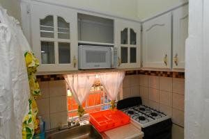 a kitchen with a stove and a microwave at La Vue 2 in Anse La Raye