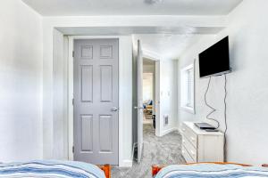 Cake by the Ocean في مدينة لينكولن: غرفة نوم بيضاء فيها سرير وتلفزيون