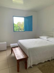 um quarto com uma cama branca e uma janela em Lostpoint Home em Monte Alto