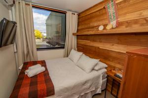 a small bedroom with a bed and a window at Hotel Cumbres del Sur in Puc&oacute;n