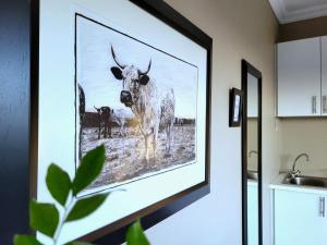 a picture of a cow on a wall in a kitchen at Deja' Blu Bed and Breakfast in East London