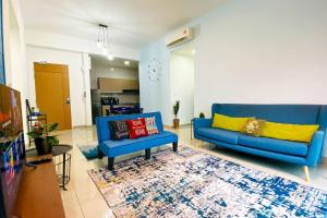 a living room with two blue couches and a rug at The Icon4 Condo in IOI City Mall Putrajaya, Netflix in Putrajaya