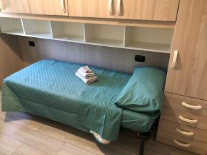 een klein bed in een kast met een groen laken bij Balai house in Porto Torres