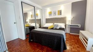 sypialnia z łóżkiem i dużym lustrem w obiekcie Departamento un dormitorio Ubicación ideal Córdoba w Córdobie