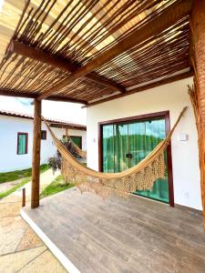 a hammock on the patio of a house at Green Village pousada Atins in Atins