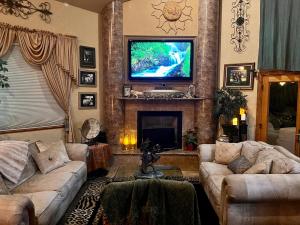 sala de estar con sofás y TV de pantalla plana. en The Oasis, en Redding