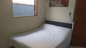 ein kleines Bett in einem kleinen Zimmer mit einem Fenster in der Unterkunft casa na vila historica in Angra dos Reis