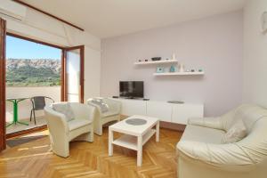 salon z białymi meblami i dużym oknem w obiekcie Apartments with parking spaces Baska, Krk - 18861 w Bašce