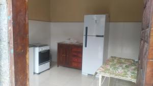 eine Küche mit einem Kühlschrank, einem Herd und einem Tisch in der Unterkunft casa na vila historica in Angra dos Reis