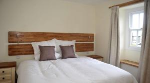 a bedroom with a large white bed with two pillows at No 2 The Forge Coniston in Coniston