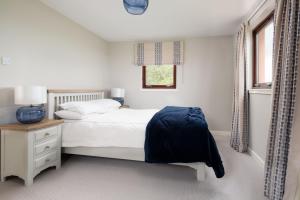 um quarto branco com uma cama e uma janela em Westwood Cottage em Longniddry