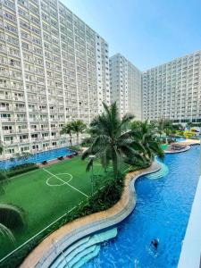 um grande edifício de apartamentos com um campo de ténis em frente a um rio em Shore Residences Facing Pool em Manila