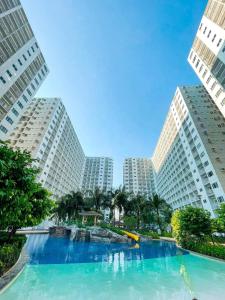 uma piscina no meio de dois edifícios altos em Shore Residences Facing Pool em Manila