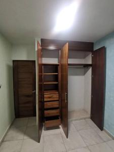a walk in closet with wooden doors and shelves at Villa el roble in Acapulco