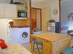 een keuken met een tafel en een wasmachine bij Studio Samoëns, 1 pièce, 4 personnes - FR-1-629-55 in Samoëns