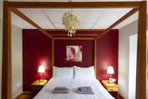 a bedroom with a large bed with red walls at Netherbeck Cottage Coniston in Coniston