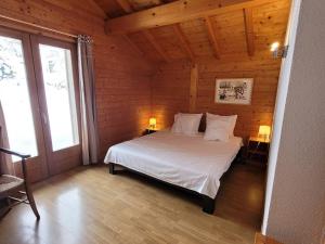 a bedroom with a bed in a wooden cabin at Chalet Les Gets, 5 pièces, 10 personnes - FR-1-598-87 in Les Gets