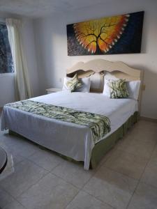 a bedroom with a large bed with a painting on the wall at Hospedaje Familiar in Oaxaca City