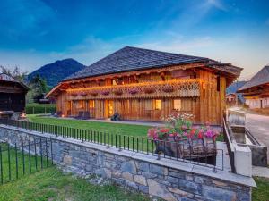 a wooden house with flowers on a stone wall at Chalet Morzine, 9 pièces, 14 personnes - FR-1-627-9 in Morzine