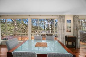 a living room with a table and a large window at Aqua Vista in Smiths Lake