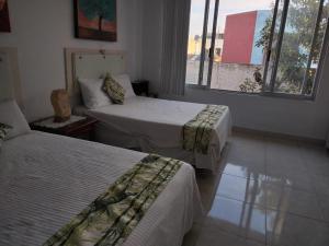 a hotel room with two beds and a window at Hospedaje Familiar in Oaxaca City