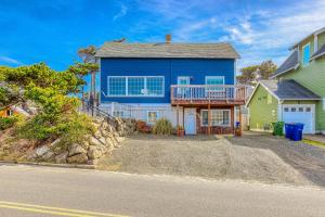 a large blue house with a balcony on a street at A Slice Above in Lincoln City