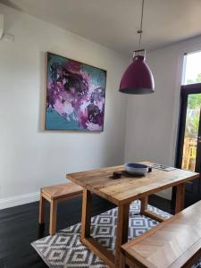 a dining room with a wooden table and a painting at Jayda in Daylesford