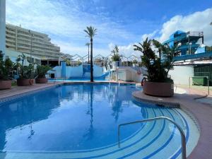 a large blue swimming pool in a resort at Modern apartment in Benalmádena with garden in Benalmádena