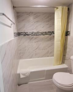 een witte badkamer met een bad en een toilet bij Budget inn in Vandalia