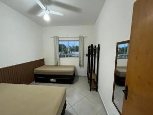 a room with two beds and a window at Rafael Apartamentos 800m da Praia da Maranduba in Ubatuba