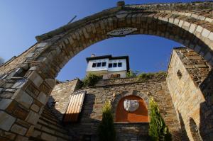 an arch in a brick wall with a building at Hotel Dryalos in Mileai