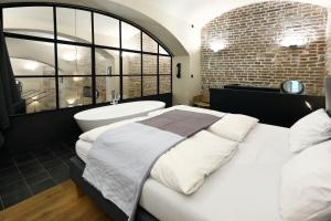 een slaapkamer met een groot bed en een bad bij American Loft in the Heart of Prague in Praag