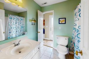 a bathroom with a white toilet and a sink at Double Blessing in North Topsail Beach +29 photos