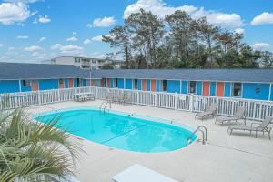 a swimming pool in front of a motel at Anchor Inn Motel in Oak Island