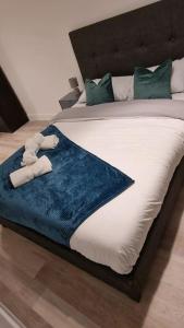 a bed with a blue blanket and stuffed animals on it at Modern Stylish Apartment in Birmingham in West Bromwich