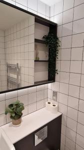 a bathroom with a sink and a mirror and a plant at Modern Stylish Apartment in Birmingham in West Bromwich