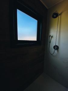 a bathroom with a window in a dark room at Refúgio Serra e Flor in Urubici