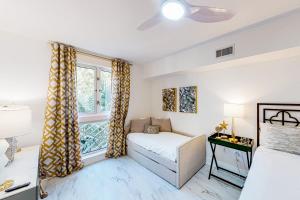 a living room with a bed and a window at Baytowne Wharf - Market Street Inn #336 in Destin