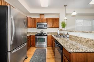 a kitchen with stainless steel appliances and wooden cabinets at Harmony Hills #237 in Anchorage