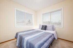 a bedroom with a bed and two windows at Harmony Hills #237 in Anchorage
