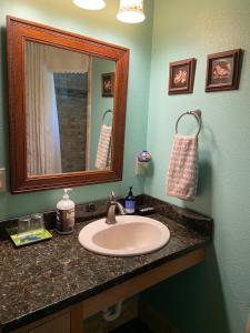 uma casa de banho com um lavatório e um espelho em Sierra Trails Inn em Mariposa