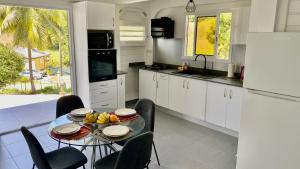 a kitchen with a table with a bowl of fruit on it at Logement de vacances in Les Abymes