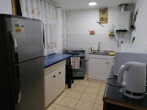金特羅的住宿－Cabaña "Descanso playero"，厨房配有不锈钢冰箱和炉灶。